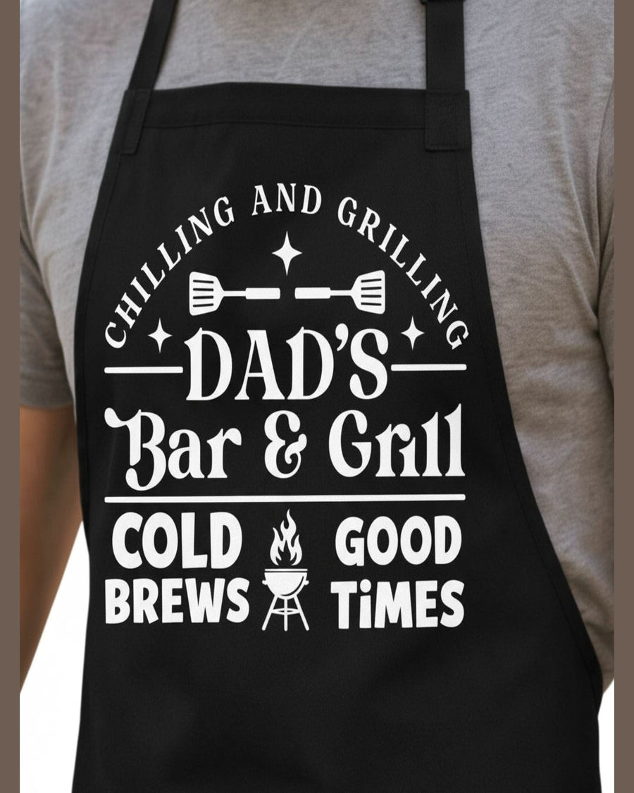 Black Dad's Bar & Grill BBQ apron front view with adjustable straps and pocket showing Chilling and Grilling design