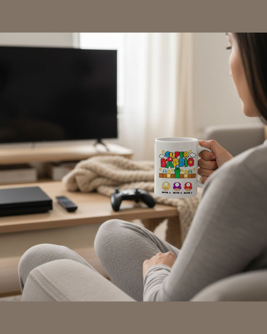 Gamer dad holding Super Daddio personalized coffee mug in living room with controller