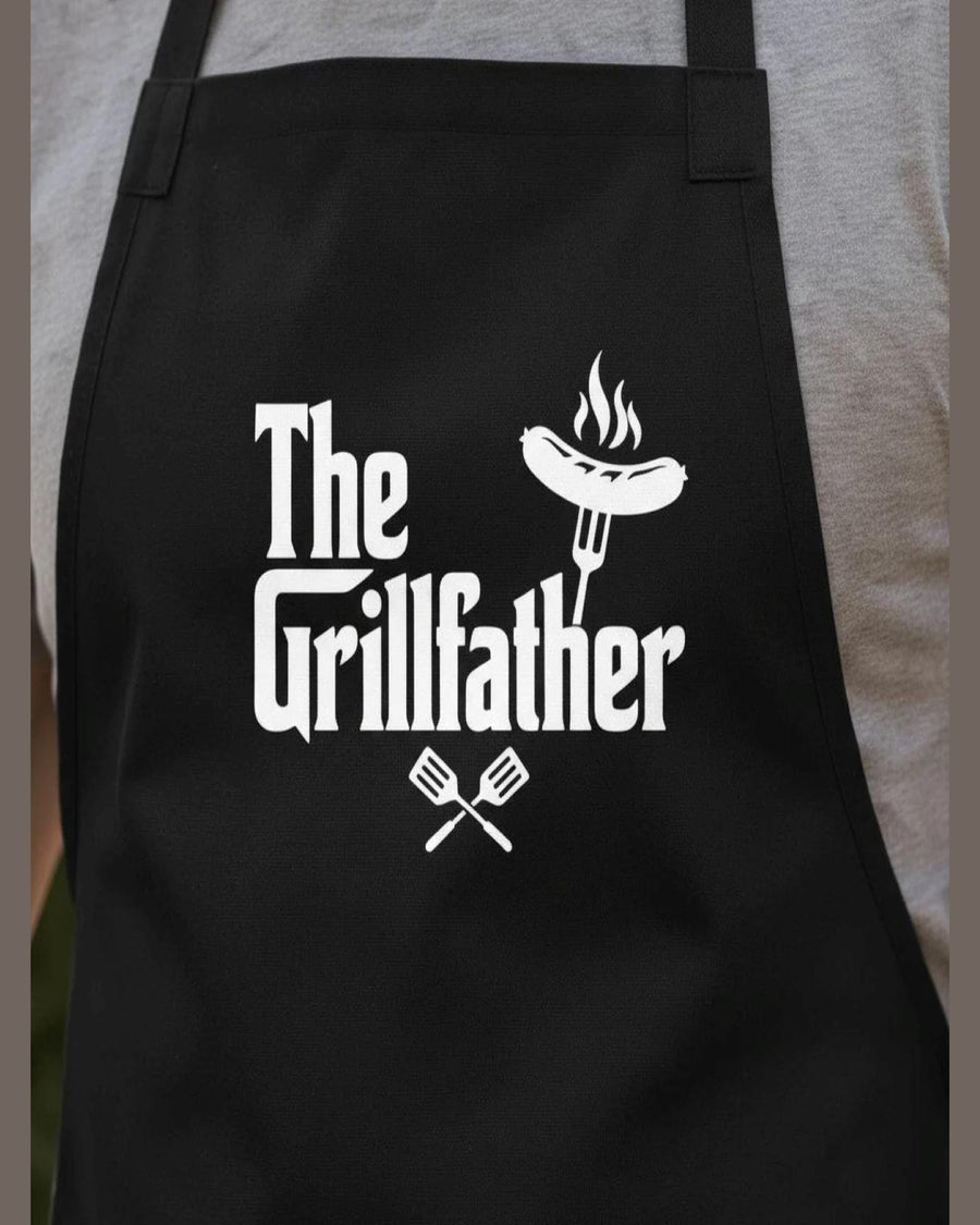 Close-up of black cotton canvas BBQ apron featuring grilled sausage graphic