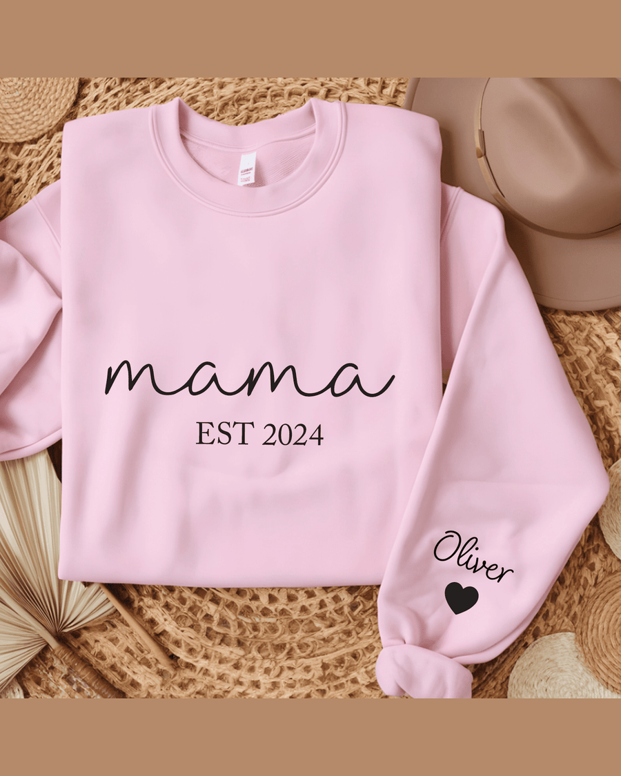 Pink custom hoodie flat lay showing 'Oliver' sleeve name and 'mama EST 2024' front text