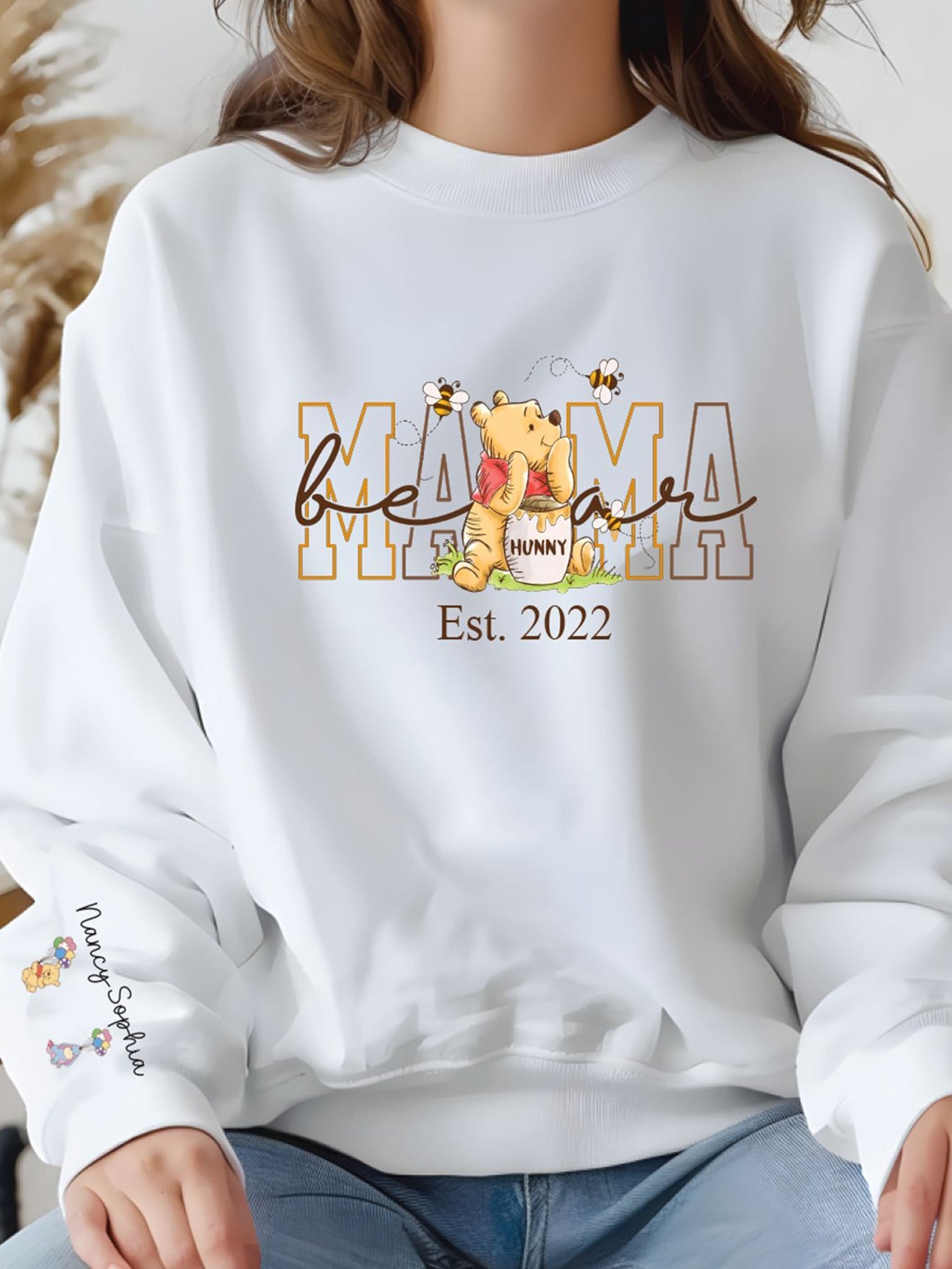 A white sweatshirt with a Winnie the Pooh-themed design and text.