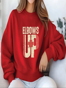 sweatshirt featuring an Elbows Up graphic with a distressed Canadian flag and red maple leaf design representing Canadian pride.