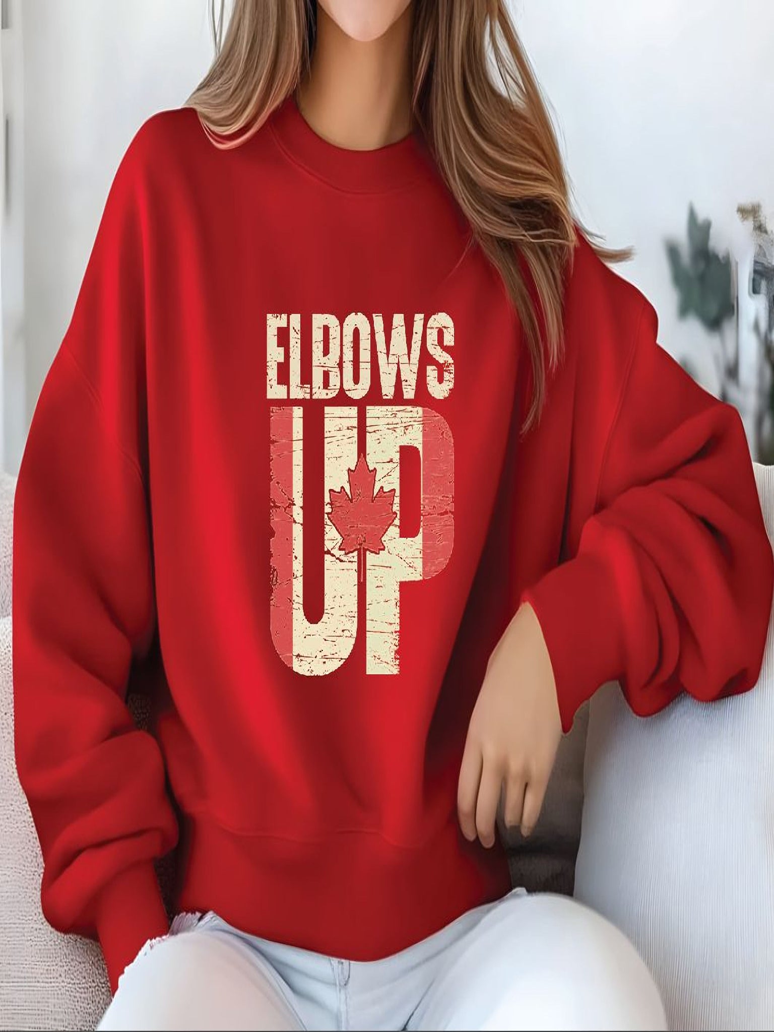 sweatshirt featuring an Elbows Up graphic with a distressed Canadian flag and red maple leaf design representing Canadian pride.