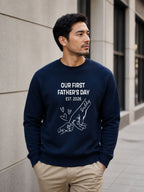 sweatshirt featuring personalized Our First Father’s Day design with minimalist daddy and baby hand outline artwork worn by male model outdoors.