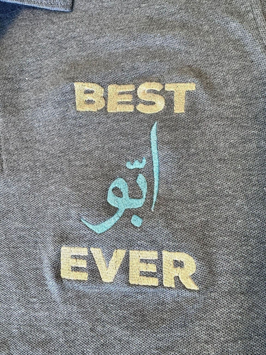 a gray fabric with the words "BEST EVER" and "الحمل" (meaning "best ever") embroidered on it.