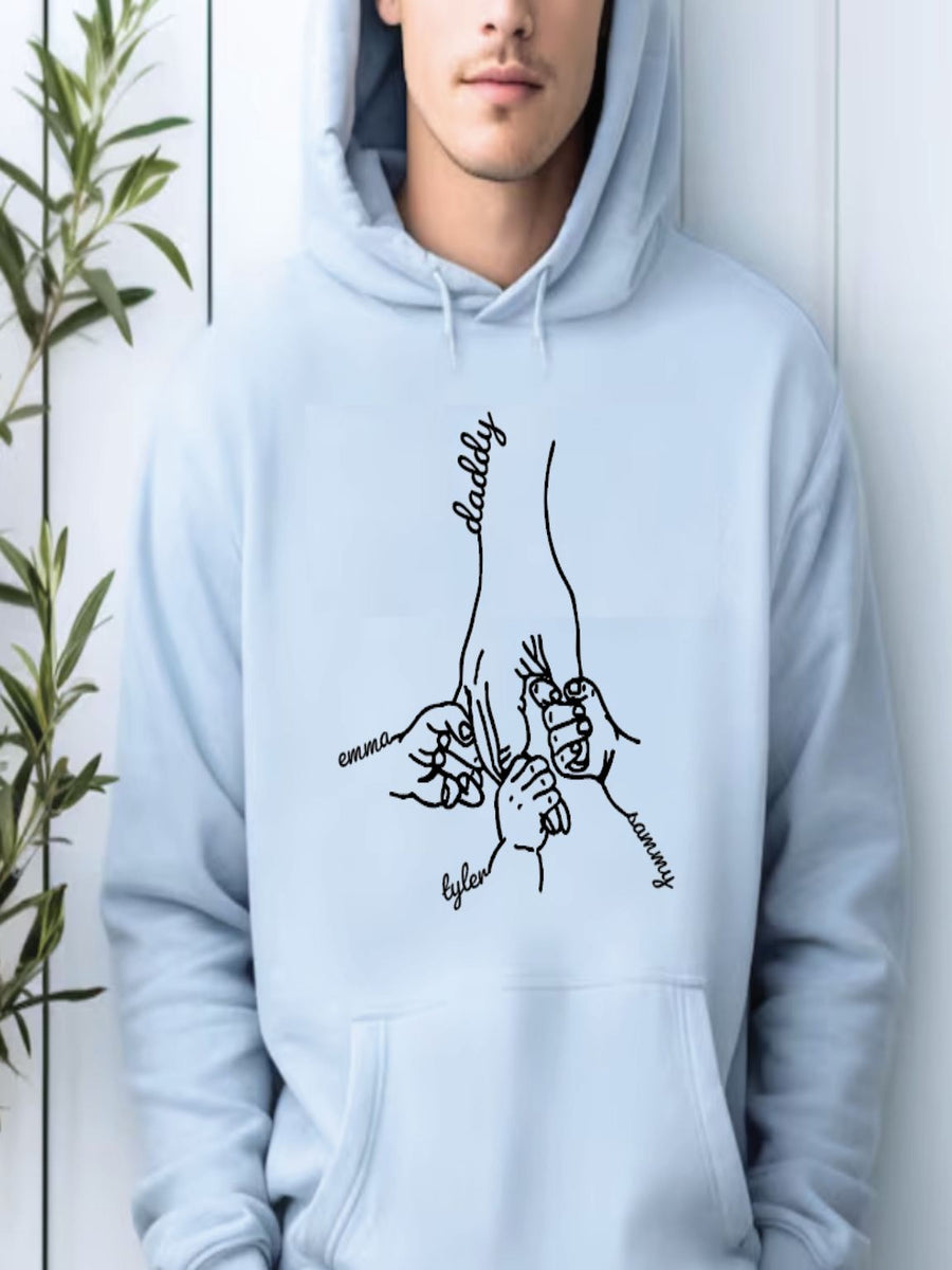 A person wearing a light blue hoodie with a graphic design depicting a hand holding a child's hand.