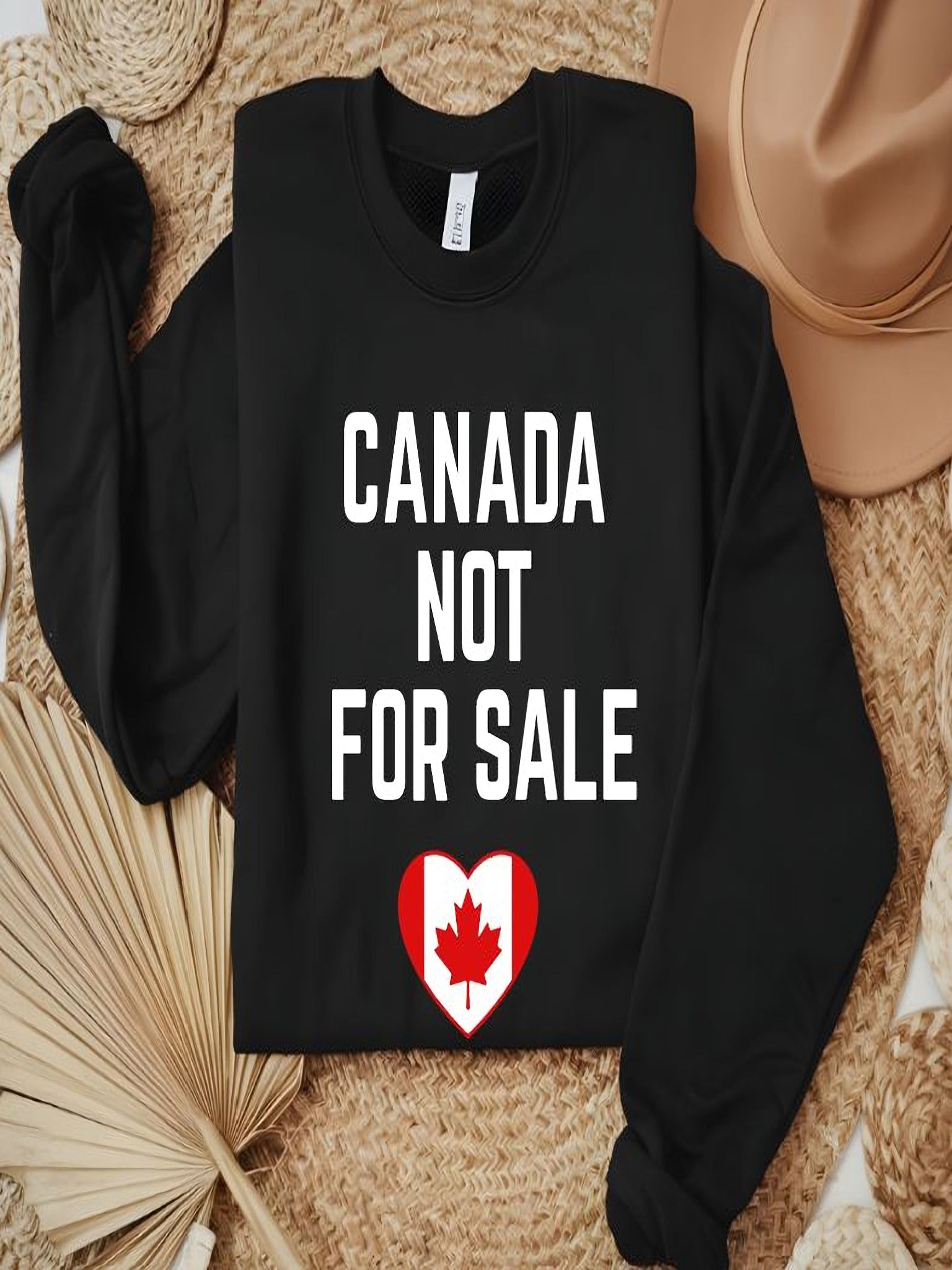 sweatshirt featuring the phrase Canada Not For Sale with a heart-shaped Canadian flag and maple leaf graphic representing Canadian pride.