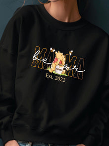 A black sweatshirt with a Winnie the Pooh logo and text printed on it.