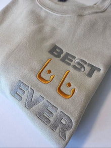 a grey sweatshirt with the text "BEST EVER" embroidered on it.