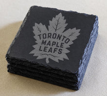A set of four dark gray slate coasters featuring the logo of the Toronto Maple Leafs hockey team.