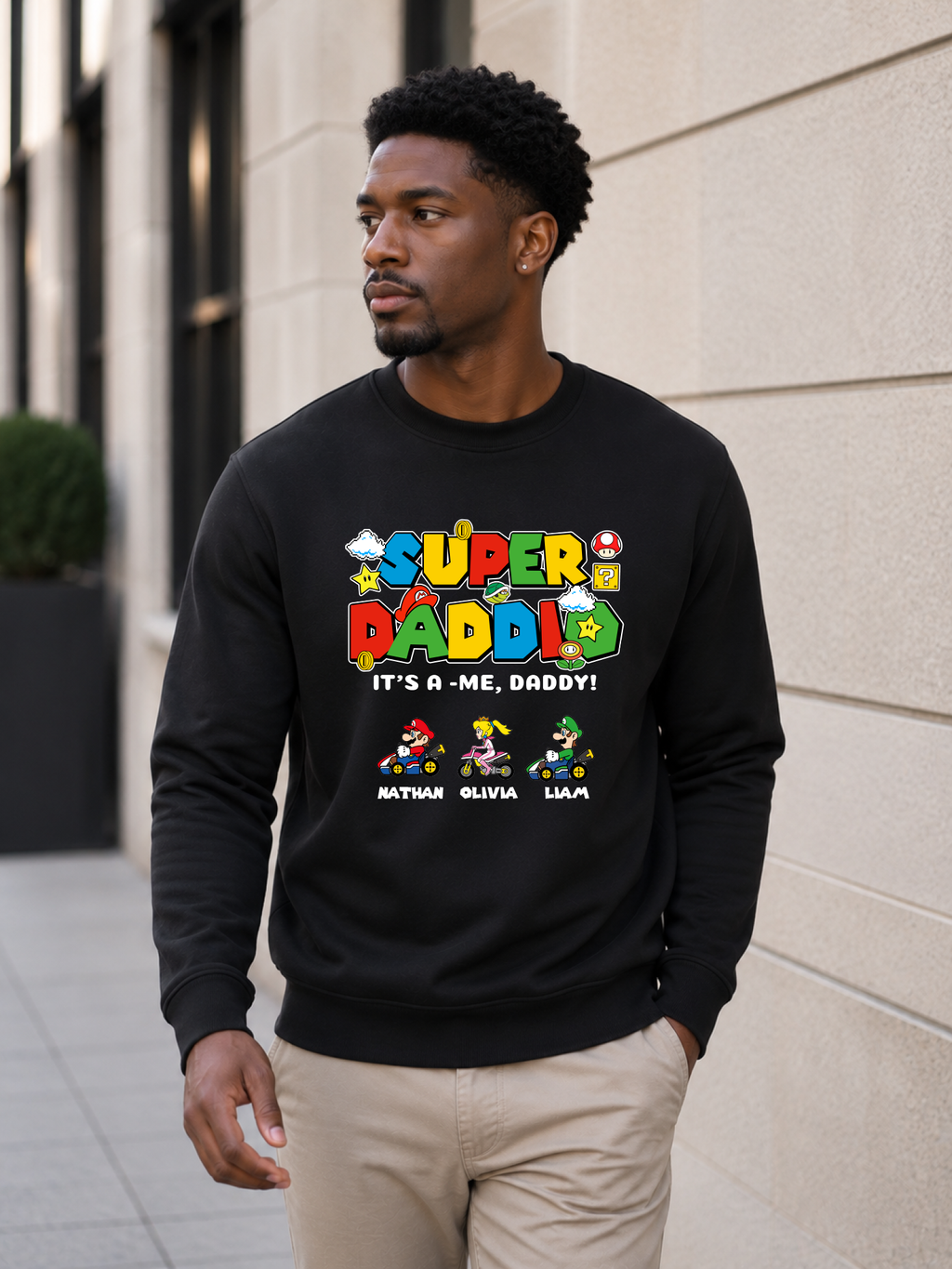 Super Daddio personalized sweatshirt featuring retro gamer-inspired colorful artwork and custom kids names worn by male model outdoors.