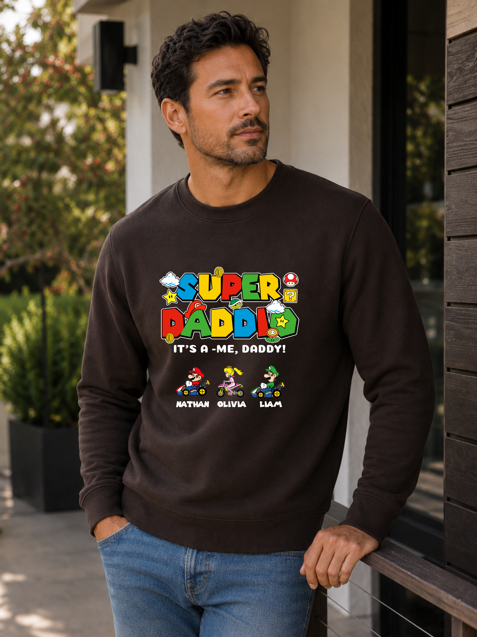 Super Daddio personalized sweatshirt featuring retro gamer-inspired colorful artwork and custom kids names worn by male model outdoors.