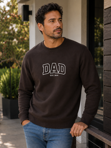 Man wearing a black sweatshirt with 'DAD EST. 2019' text