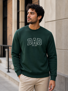 Man wearing a black sweatshirt with 'DAD EST. 2019' text