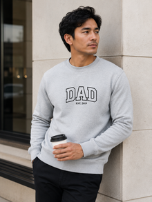 Man wearing a black sweatshirt with 'DAD EST. 2019' text