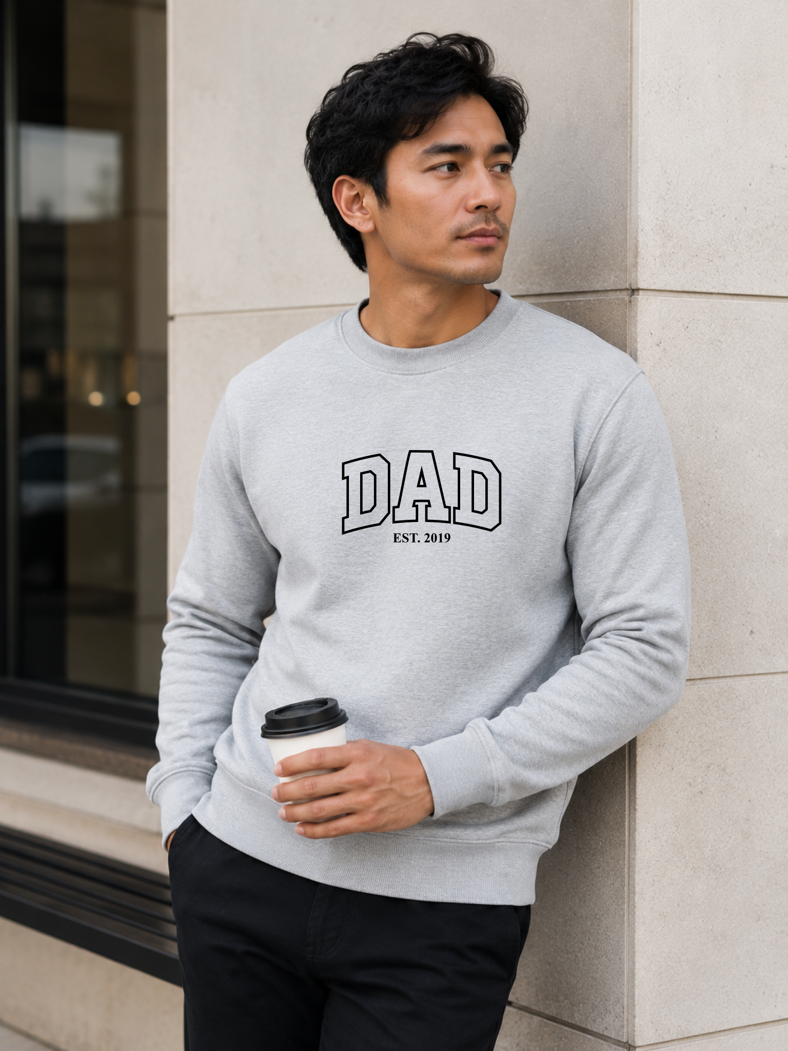 Man wearing a black sweatshirt with 'DAD EST. 2019' text