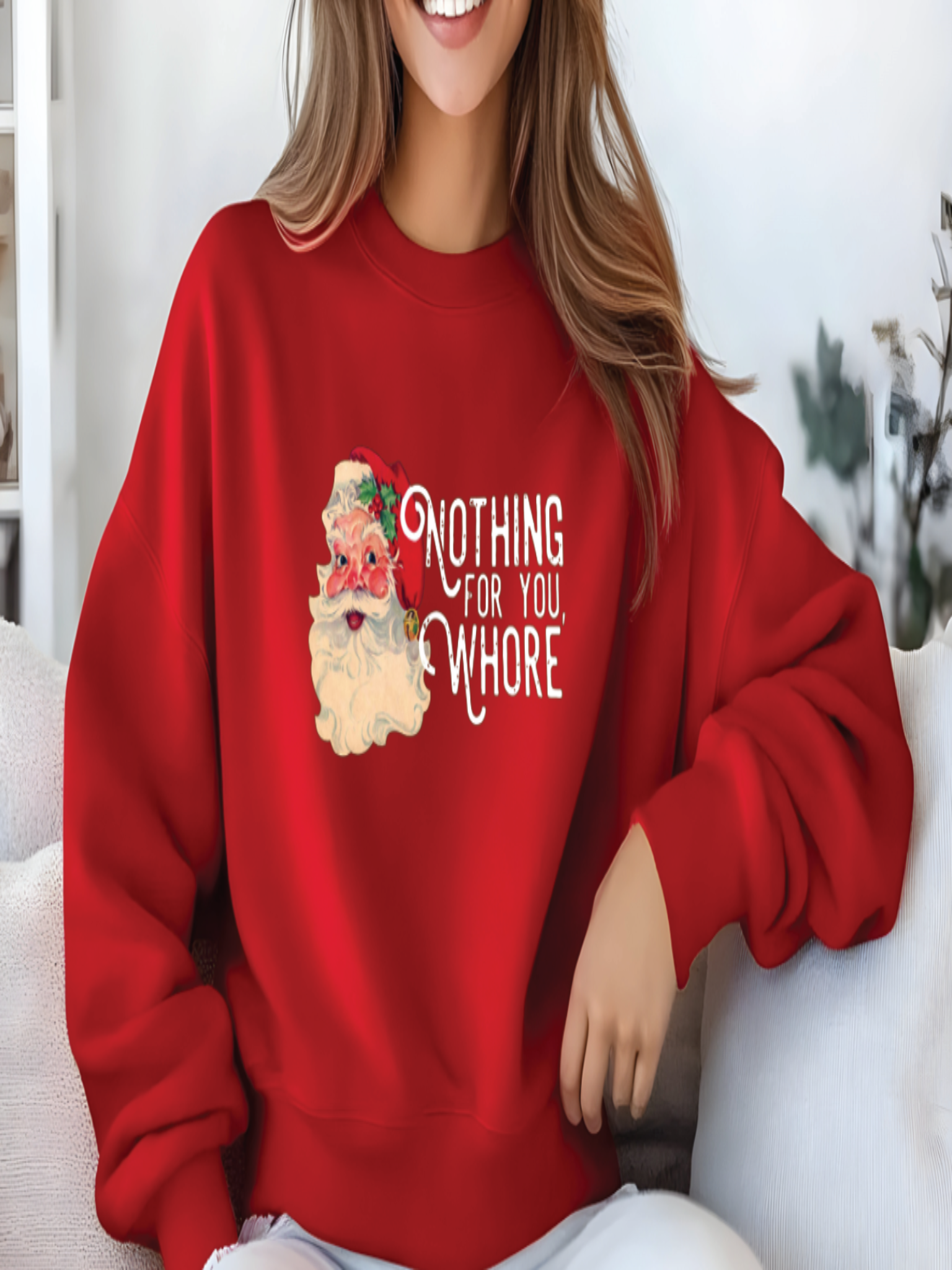 Person wearing a red sweatshirt with a graphic and text, sitting on a white couch.