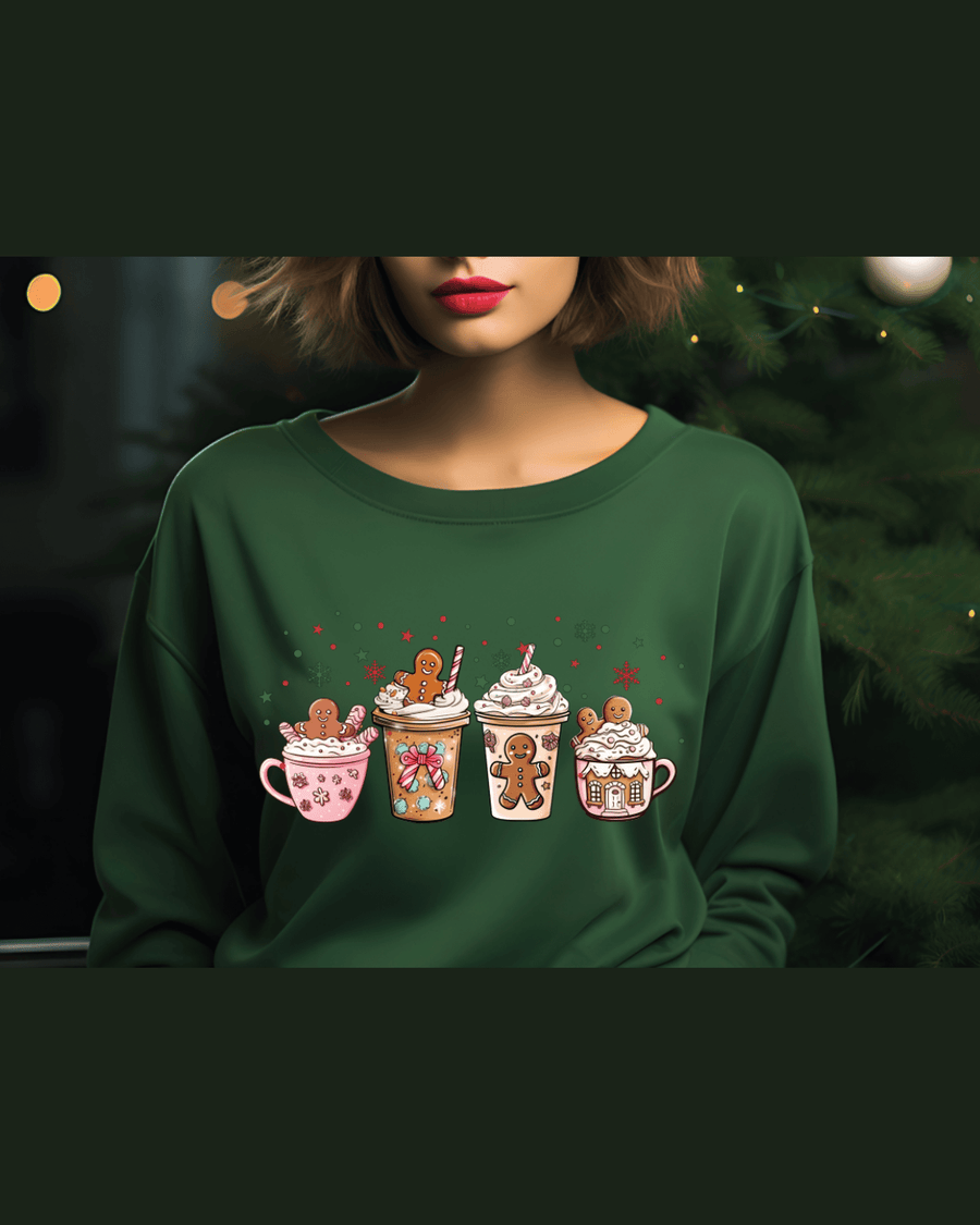 Green cozy Christmas sweatshirt with illustrated holiday drinks in front of decorated tree