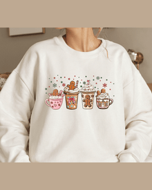 White unisex Christmas hoodie with four illustrated holiday drink mugs and festive snowflakes