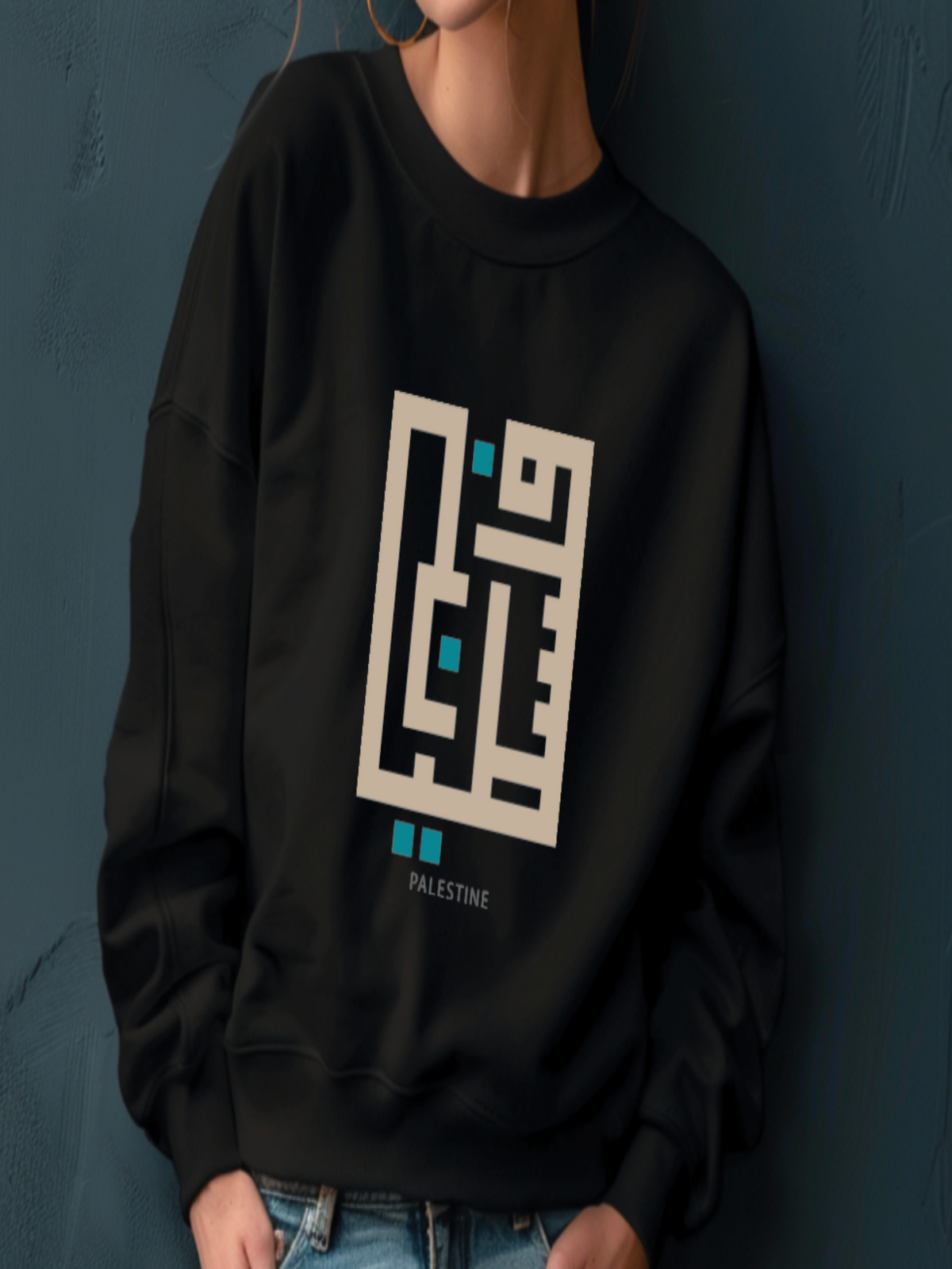 Person wearing a black sweatshirt with a geometric design and 'Palestine' text against a dark background