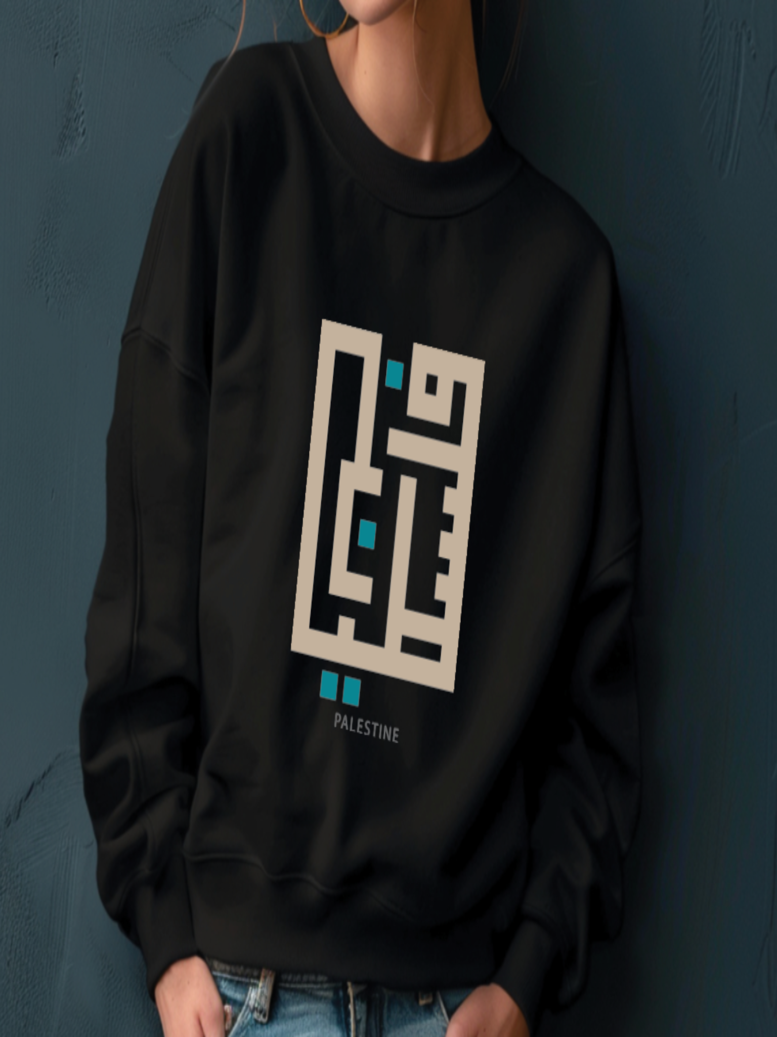 Person wearing a black sweatshirt with a geometric design and 'Palestine' text against a dark background