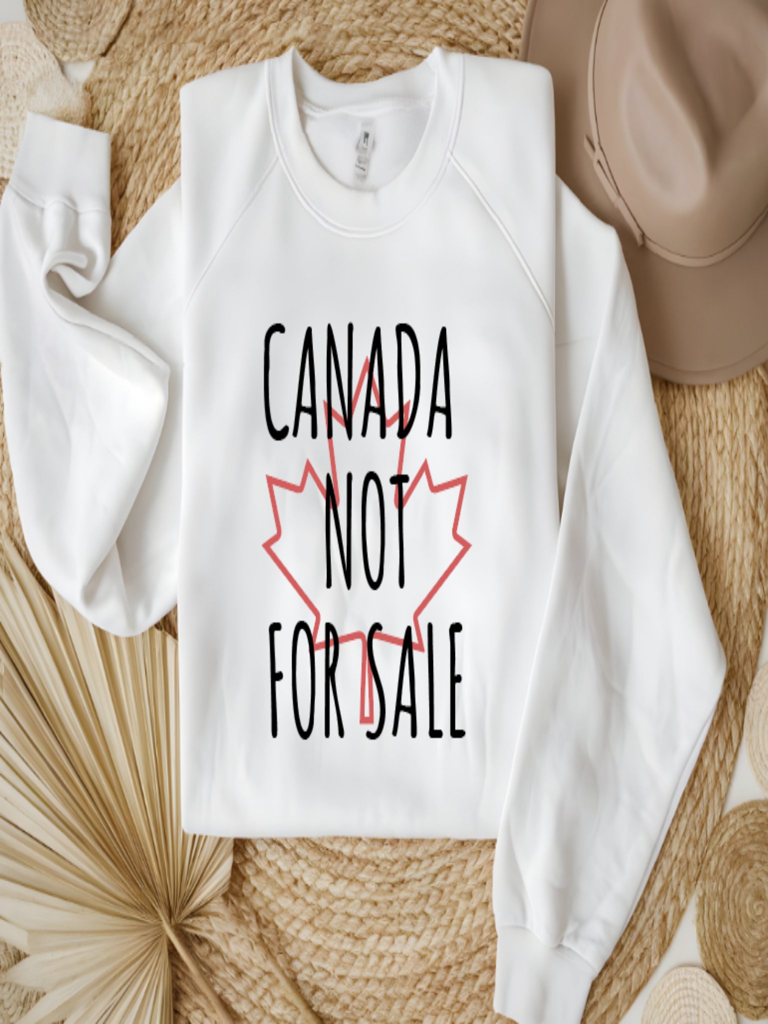 sweatshirt featuring the phrase Canada Not For Sale over a red maple leaf outline in a minimalist Canadian pride design.