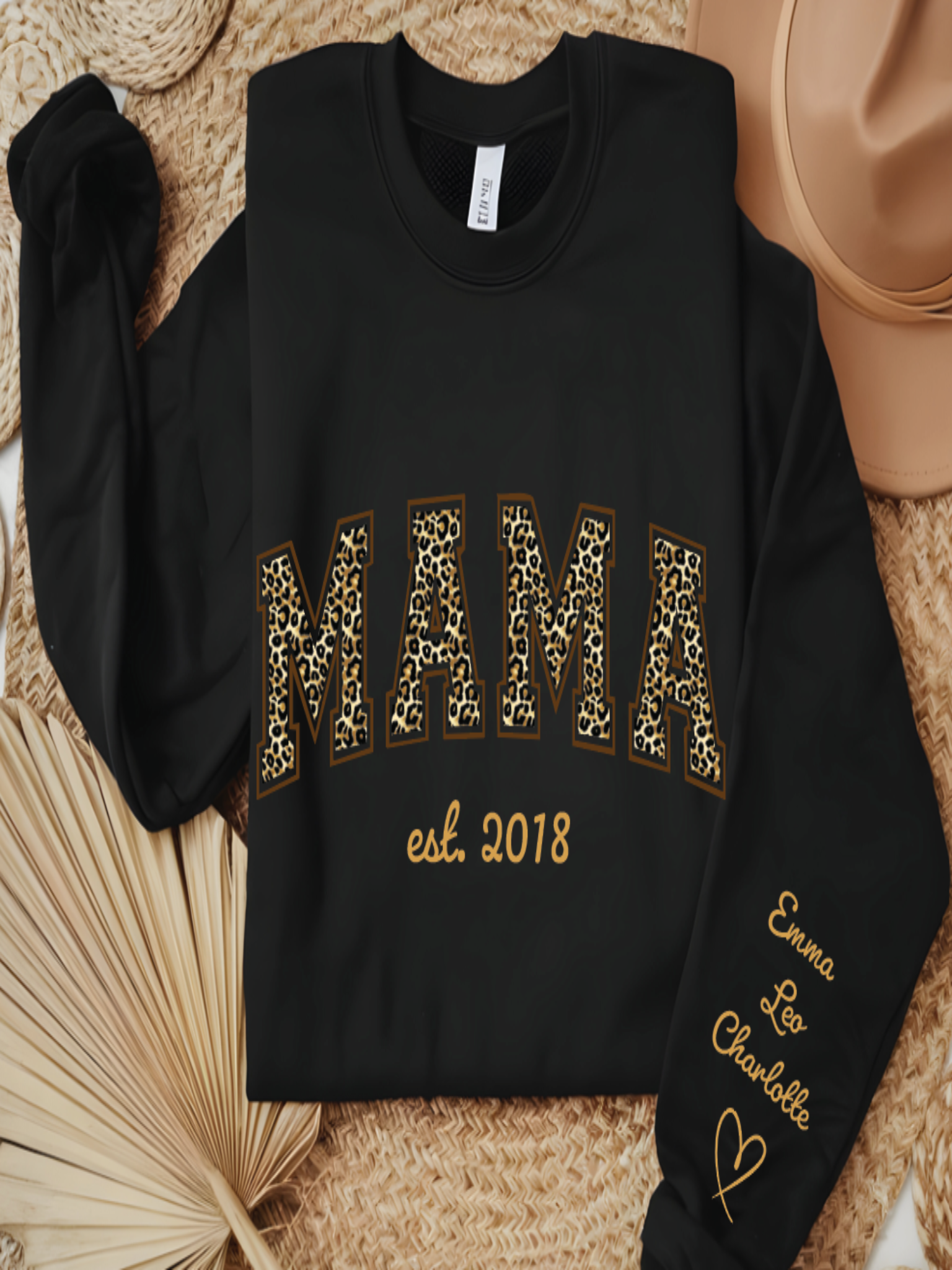 Black sweatshirt with 'MAMA est. 2018' text on a textured surface