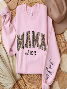 Pink sweatshirt with 'MAMA est. 2018' text on a textured surface