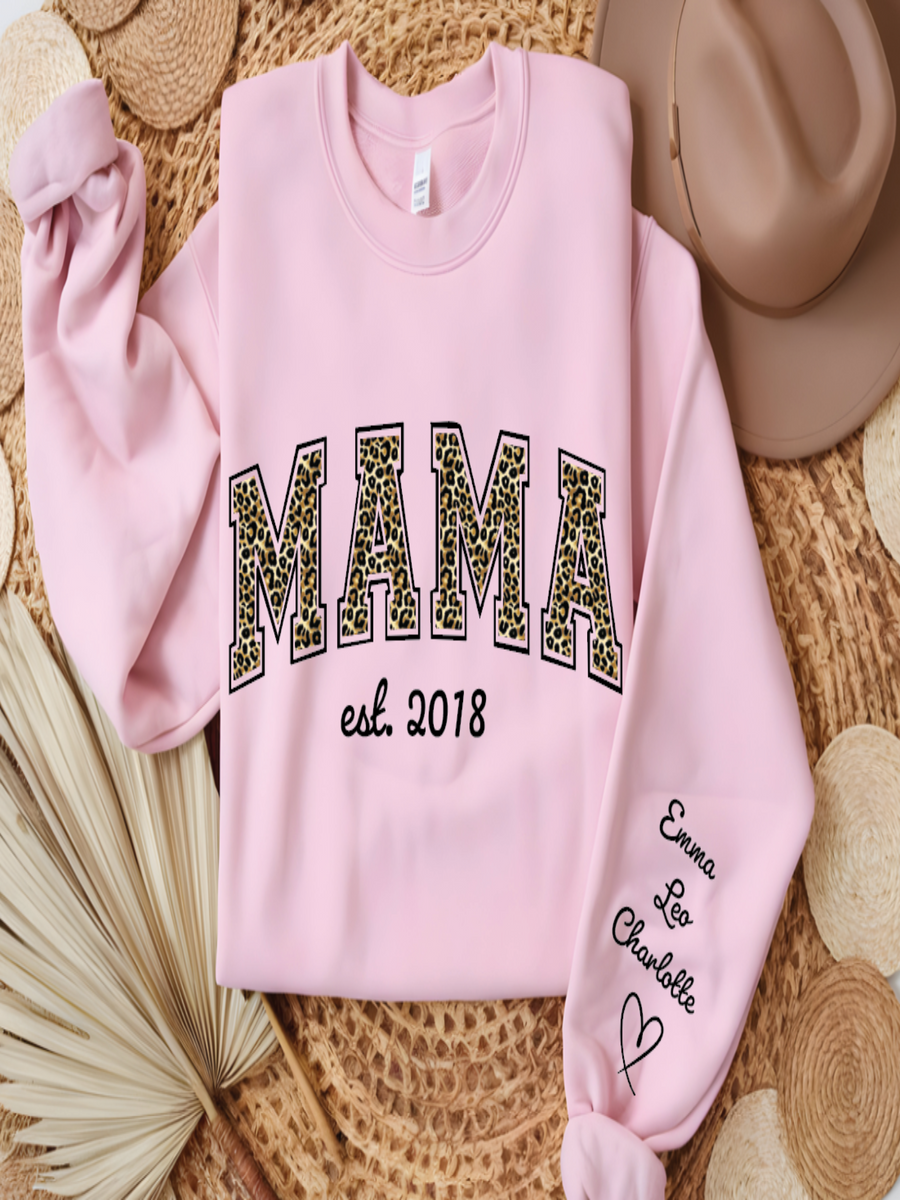 Pink sweatshirt with 'MAMA est. 2018' text on a textured surface