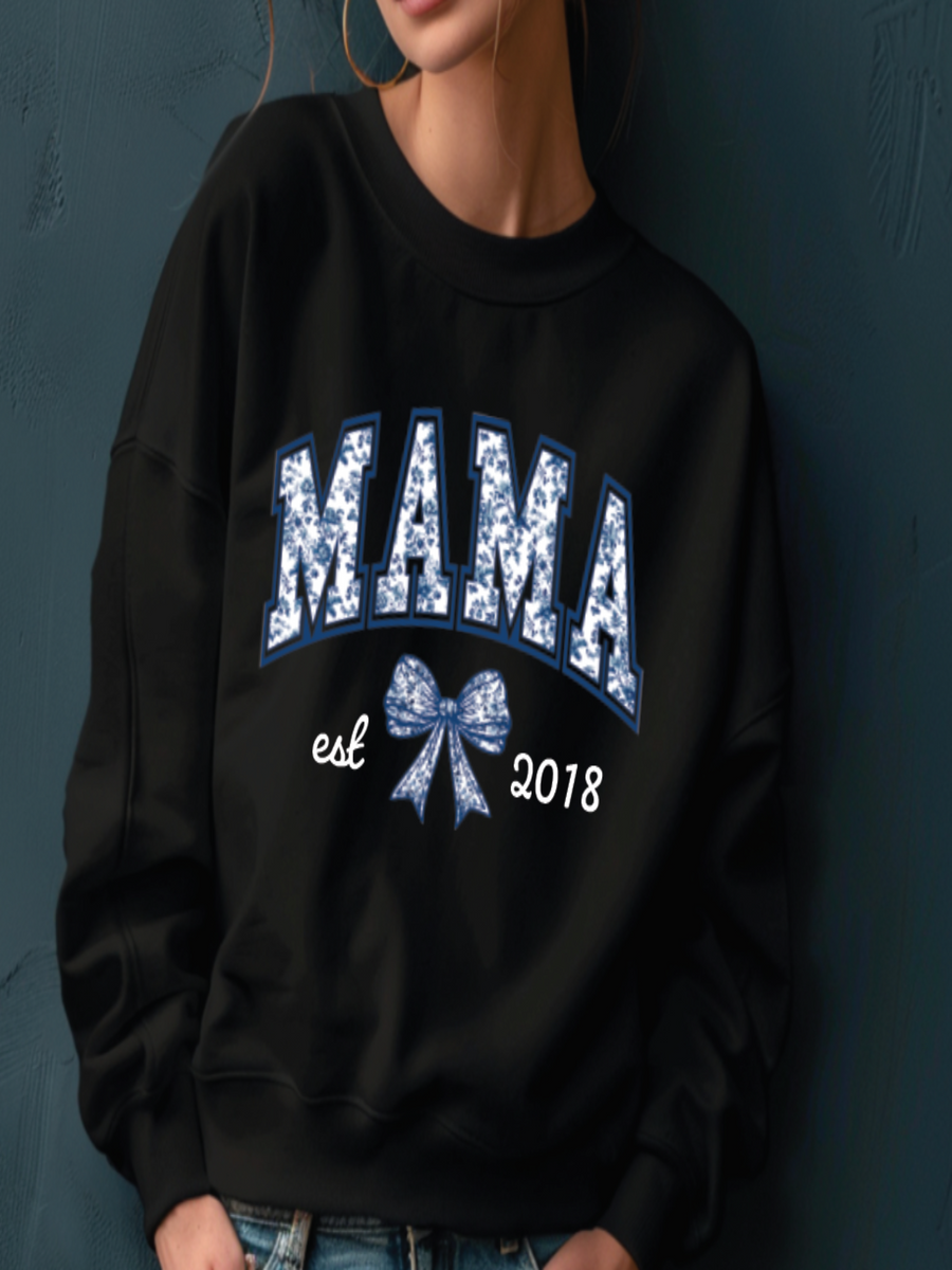 Black sweatshirt with 'MAMA est 2018' text and blue bow design on a dark background
