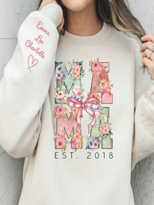 Person wearing a cream sweatshirt with floral 'MAMA' design and personalized text.
