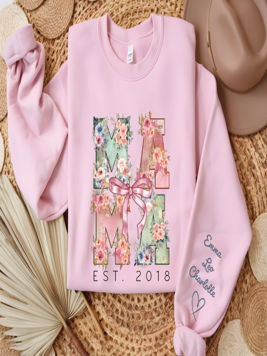 Pink sweatshirt with floral 'MAMA' design and text on a textured surface
