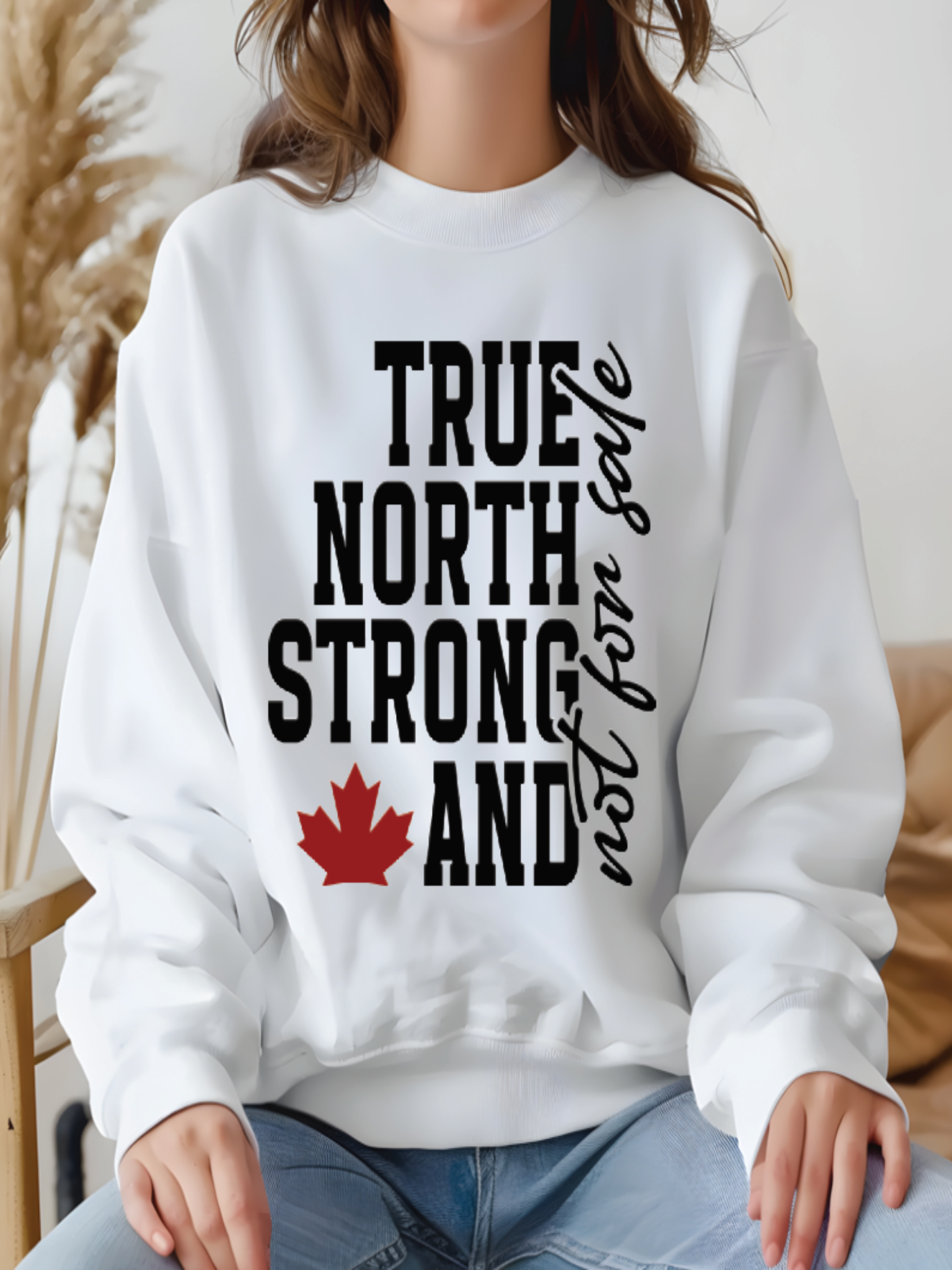 sweatshirt featuring the phrase True North Strong and Free with a red maple leaf graphic in a bold Canadian pride design.