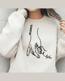 Light beige graphic sweatshirt showing two hands holding labeled Mama and Tyler in black line art