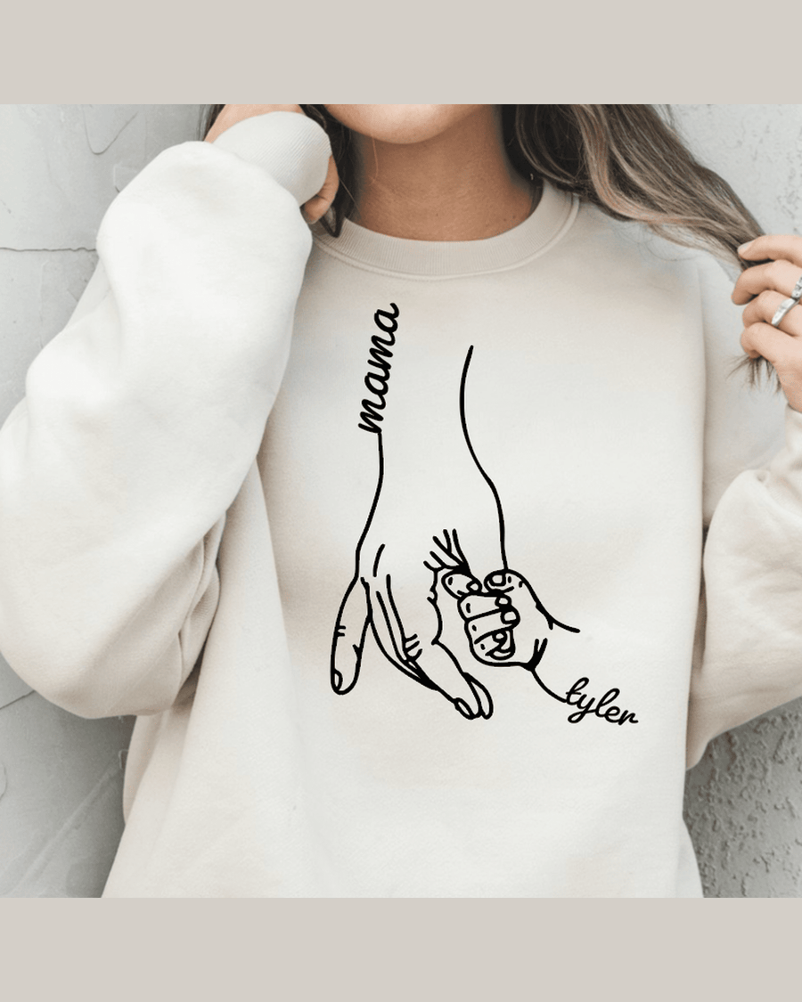 Light beige graphic sweatshirt showing two hands holding labeled Mama and Tyler in black line art