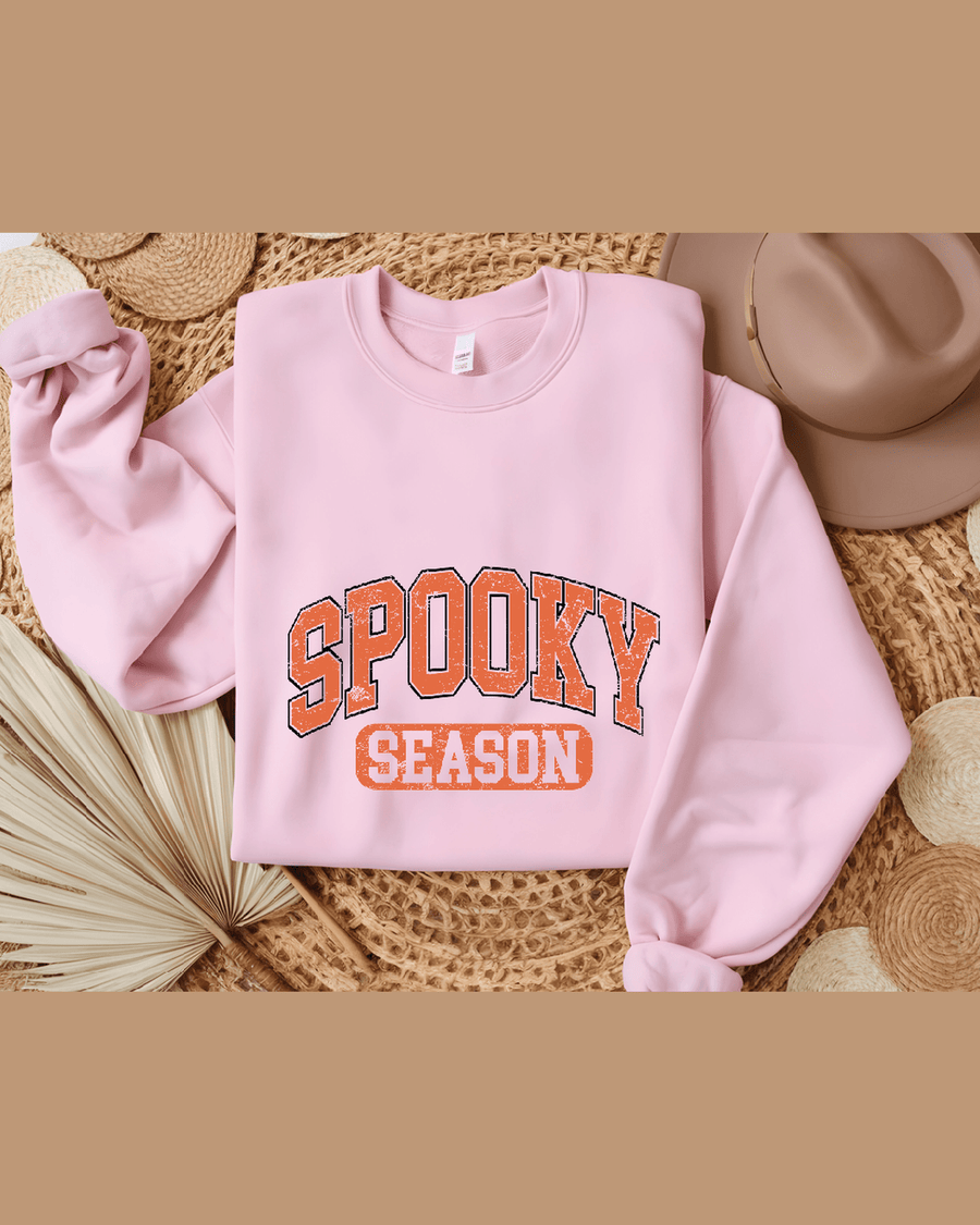 Pink cozy custom hoodie with knotted sleeves and Spooky Season graphic