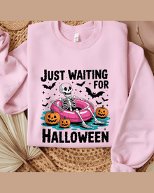 Pink Halloween skeleton hoodie with 'Just Waiting for Halloween' graphic and pumpkins