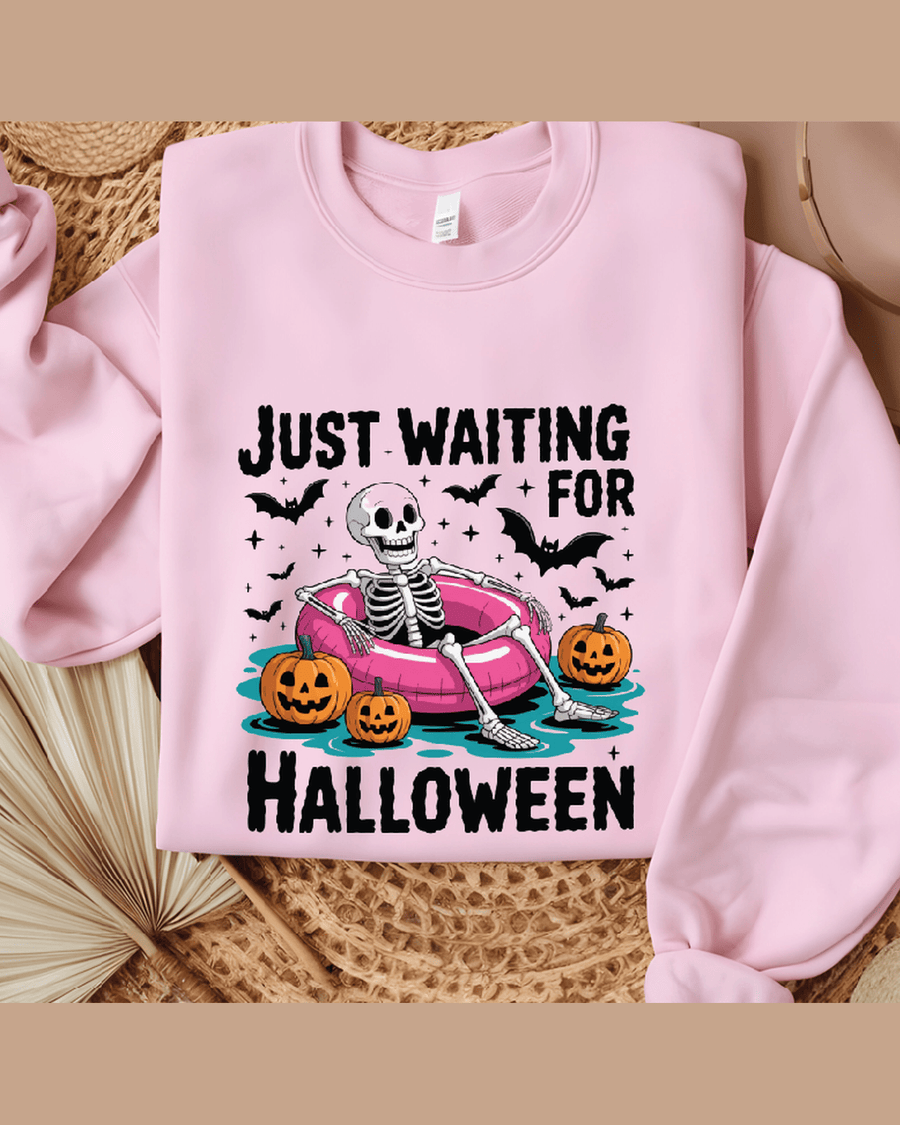 Pink Halloween skeleton hoodie with 'Just Waiting for Halloween' graphic and pumpkins