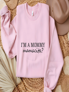 Pink sweatshirt with text 'I'm a mommy mamacita?' on a textured surface