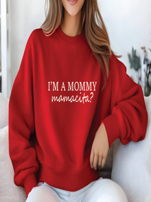 Person wearing a red sweatshirt with text sitting on a couch.