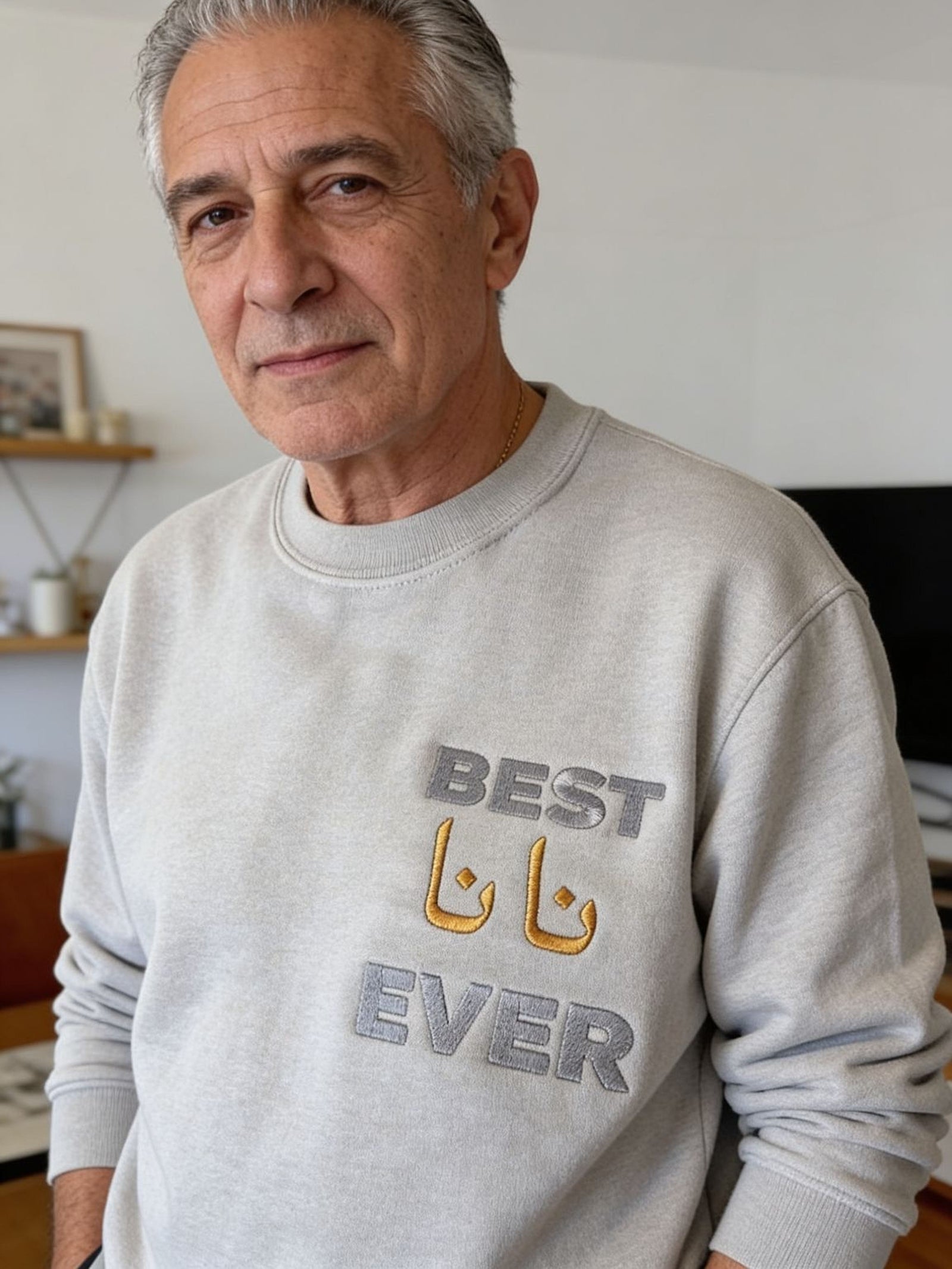 A man wearing a grey sweatshirt with the text "BEST EVER" printed on it.