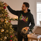 A man in a black hoodie decorating a Christmas tree with ornaments and lights.