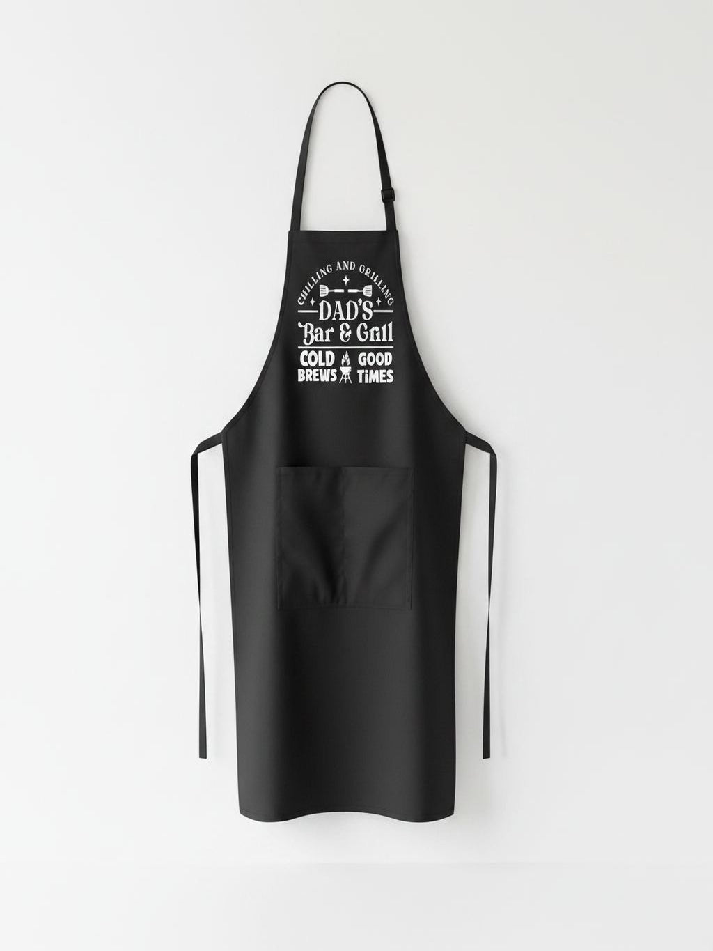 Dad’s Bar and Grill apron featuring funny BBQ typography design worn by man grilling outdoors in backyard.
