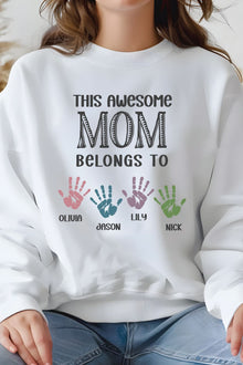 A person wearing a white sweatshirt with text and handprints printed on it.