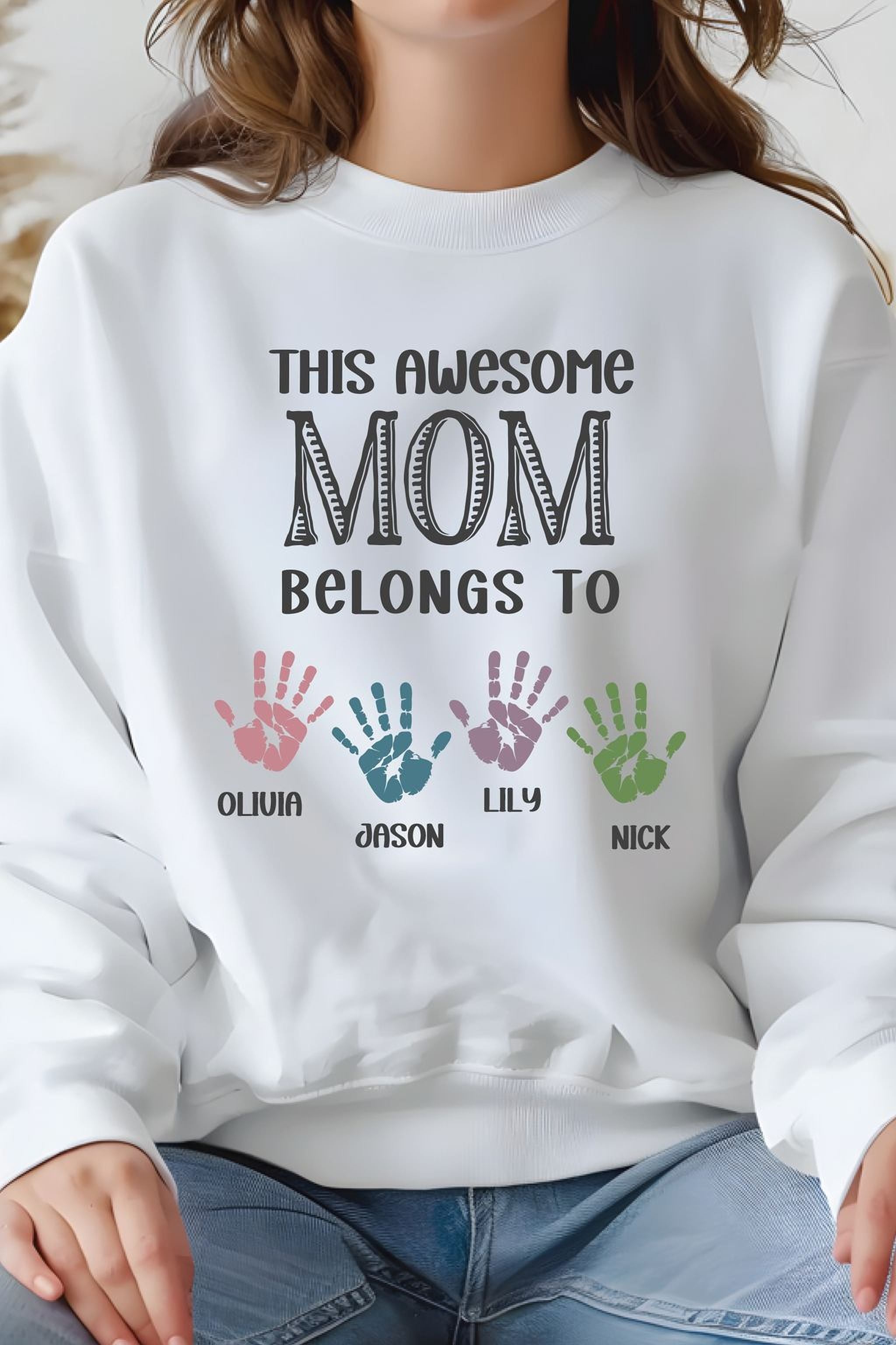 A person wearing a white sweatshirt with text and handprints printed on it.