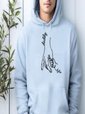 A person wearing a light blue hoodie with a graphic design depicting a hand holding a child's hand.