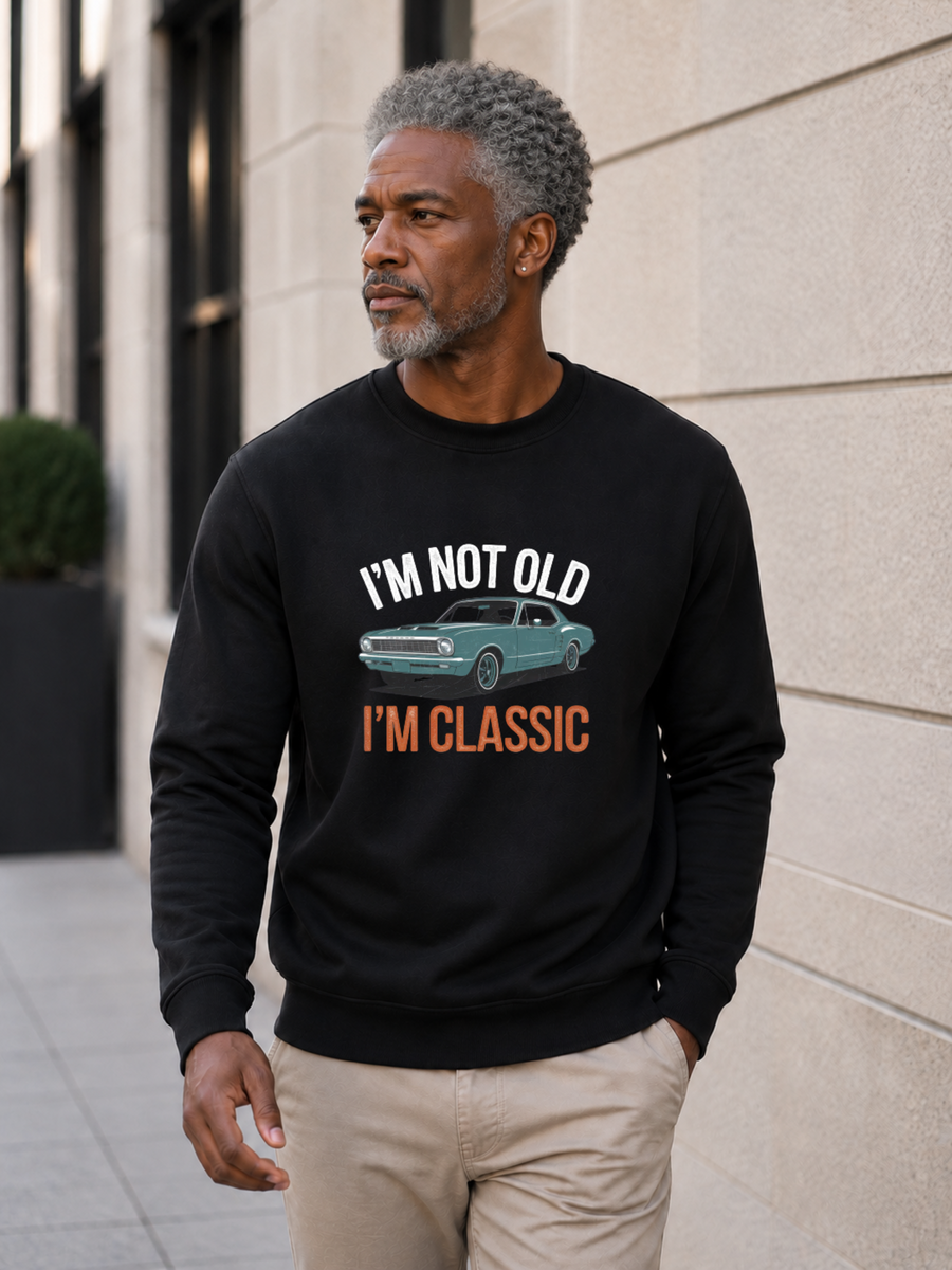 I'm Not Old I'm Classic sweatshirt featuring a vintage muscle car graphic and funny retro slogan worn by male model outdoors.