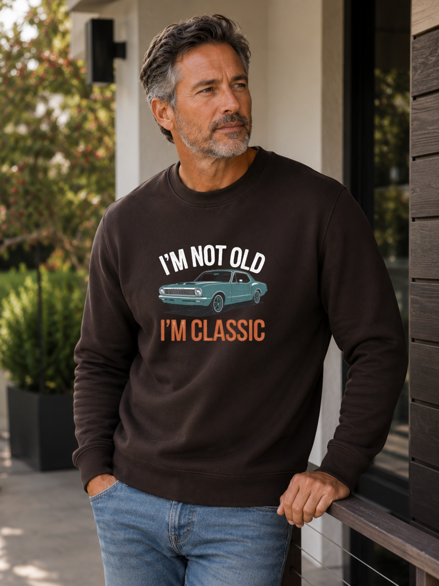 I'm Not Old I'm Classic sweatshirt featuring a vintage muscle car graphic and funny retro slogan worn by male model outdoors.