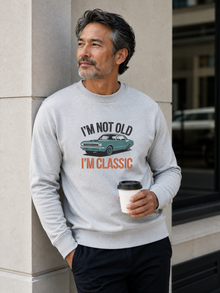 I'm Not Old I'm Classic sweatshirt featuring a vintage muscle car graphic and funny retro slogan worn by male model outdoors.