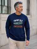 I'm Not Old I'm Classic sweatshirt featuring a vintage muscle car graphic and funny retro slogan worn by male model outdoors.